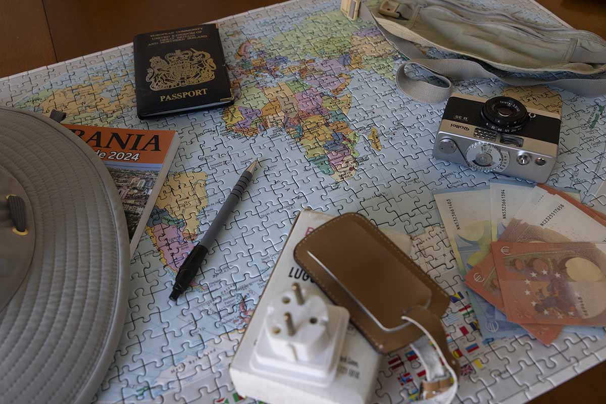 Image of travel planning items - passport, adaptor, cash, tropical hat