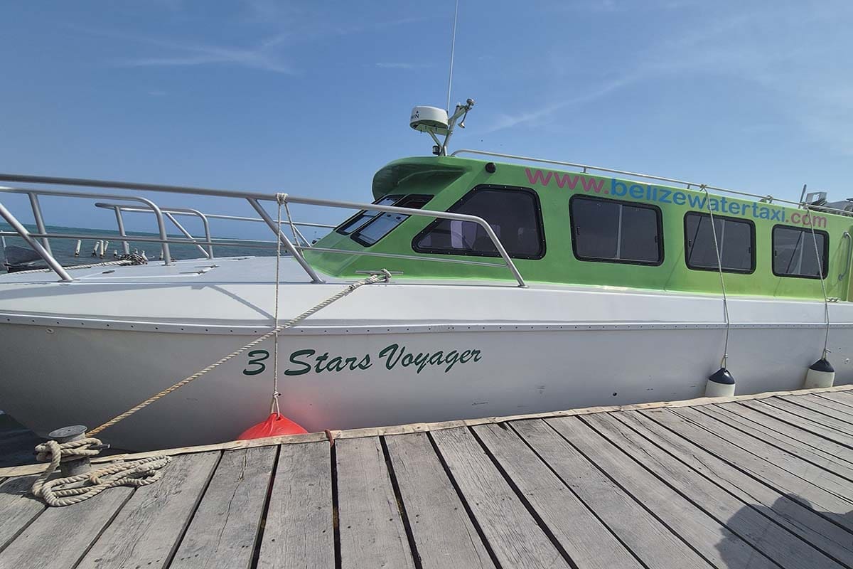 Green and white painted boat tied up at a wooden jetty